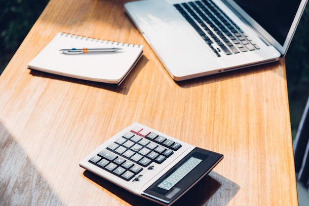 Computador portátil de negócios do espaço de trabalho e calculadora no escritório da mesa