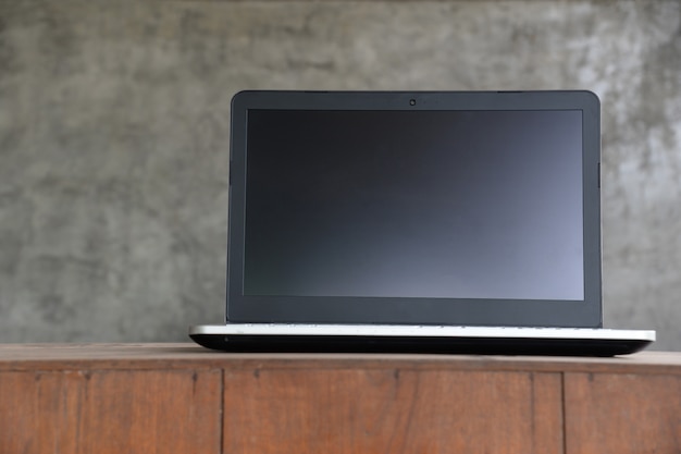 Foto computador portátil laptop com tela em branco na mesa de madeira