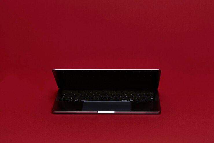 Foto computador portátil refletor em um fundo vermelho