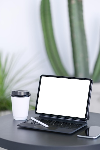 Computador tablet smartphone e xícara de café na mesa de madeira preta