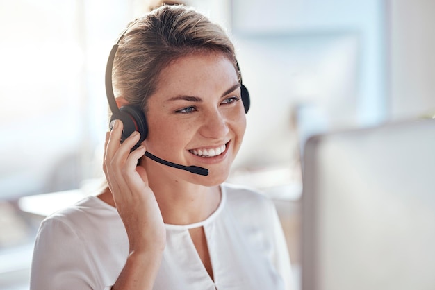 Computadora del centro de llamadas y sonrisa con una mujer en la oficina para soporte técnico y asesoramiento de servicio al cliente Tecnología contáctenos y comunicación con un operador de empleado feliz en la agencia de asistencia