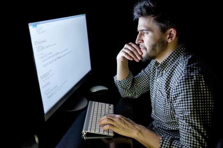 Foto computadora desarrolladora de software en la oscura oficina en casa