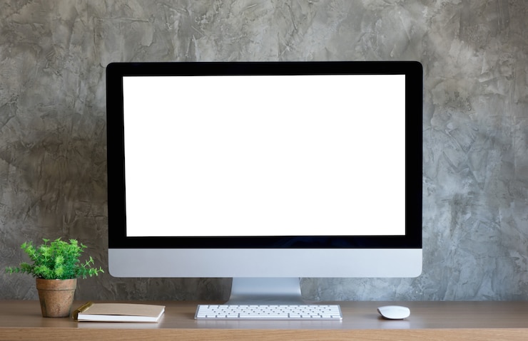 Foto computadora de escritorio en el escritorio con pantalla en blanco