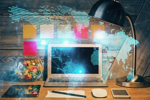 Computadora en el escritorio con holograma de red social Doble exposición Concepto de conexiones internacionales de personas