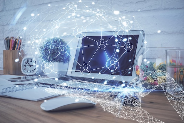 Computadora en el escritorio con holograma de red social Múltiple exposición Concepto de conexiones internacionales de personas