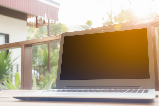 Computadora en un escritorio en un jardín soleado