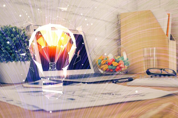 Computadora en el escritorio de la oficina con holograma de icono de bombilla Doble exposición Concepto de idea