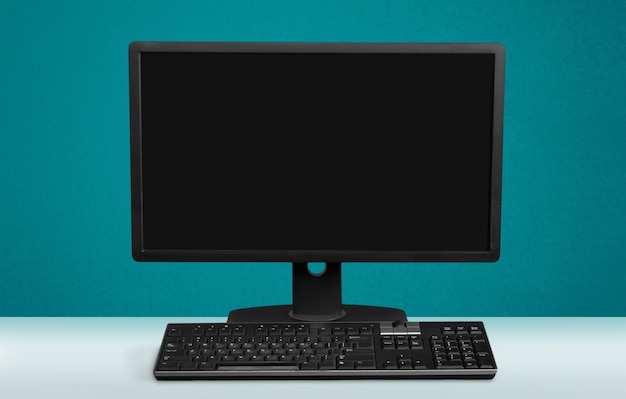 Computadora de escritorio y teclado en el fondo