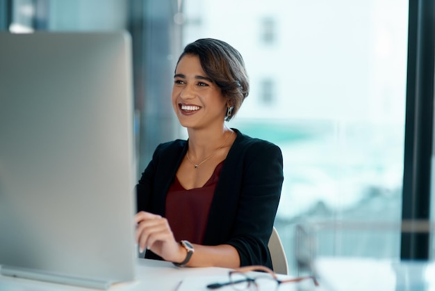 Computadora feliz y mujer de negocios con administración de software de solución en línea y revisión de la compañía de lectura Planificación de sitios web de trabajo y sonrisa de trabajador profesional o persona en PC de escritorio en la oficina