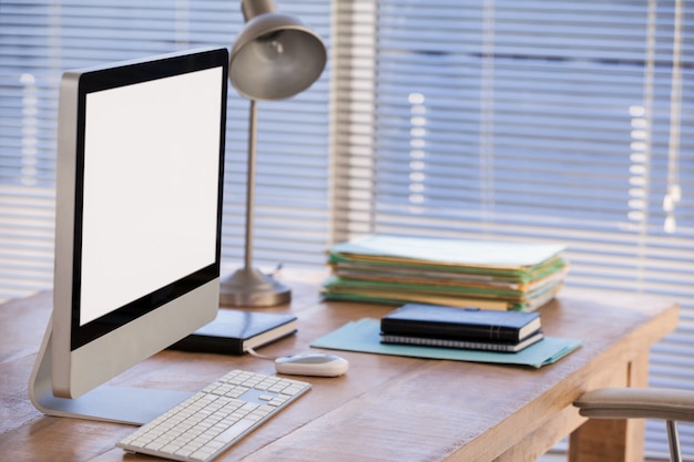 Computadora y libros en la mesa de trabajo