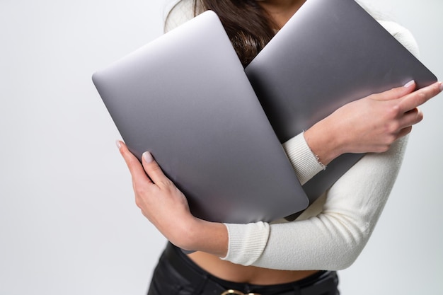 Computadora moderna con una computadora portátil gris en forma sosteniendo en manos de una mujer