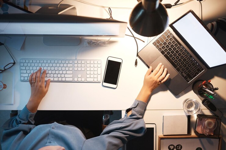 Foto computadora de mujer de negocios y manos escribiendo en el teclado arriba por la noche con pc portátil y teléfono en el escritorio de la oficina para codificación de software y técnico de ti de ingeniería que trabaja en investigación y programación