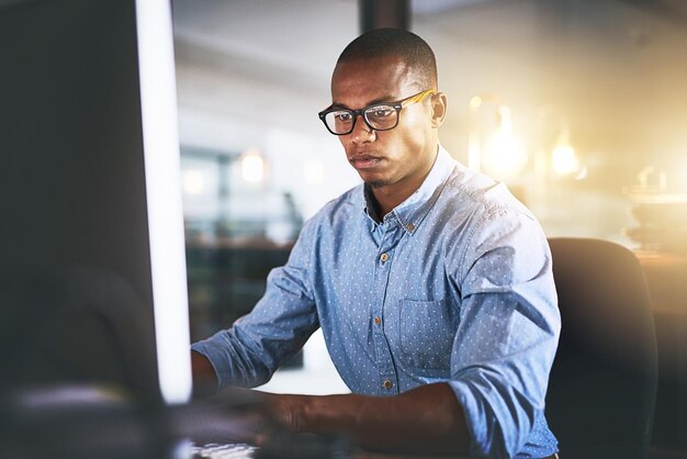 Computadora de oficina y negocios hombre negro por la noche para investigación de sitios web y programación en el escritorio Desarrollador de Startup y trabajador en línea para actualización de software redes y trabajo en diseño web