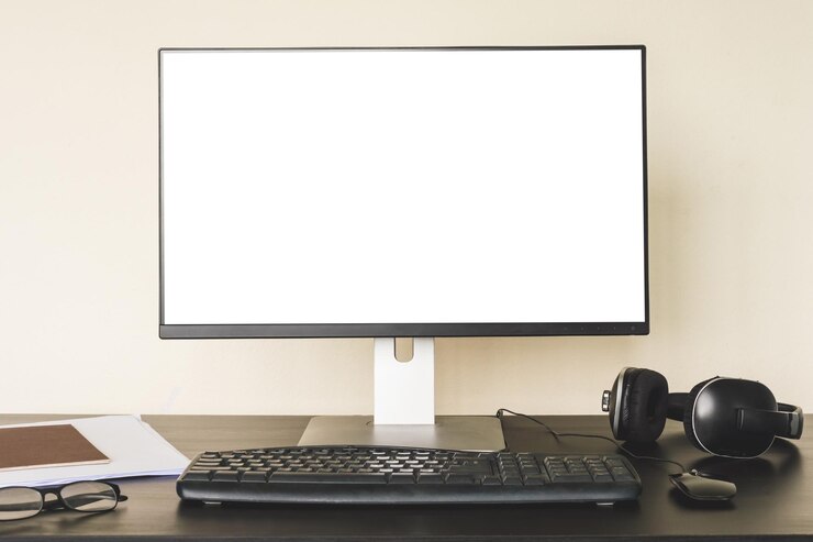 Foto computadora con pantalla blanca en el escritorio