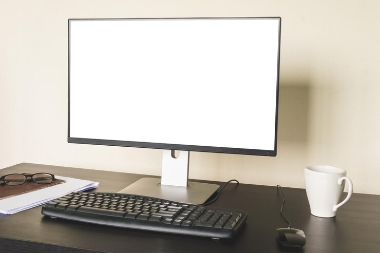 Foto computadora con pantalla blanca en el escritorio