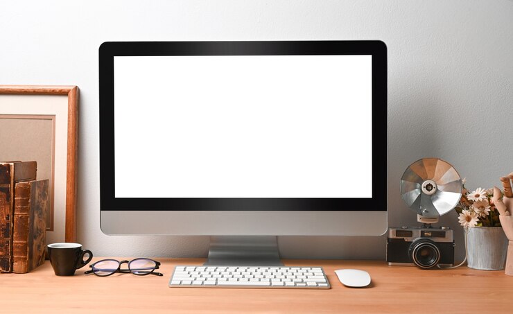Foto computadora con pantalla vacía sobre mesa de madera.