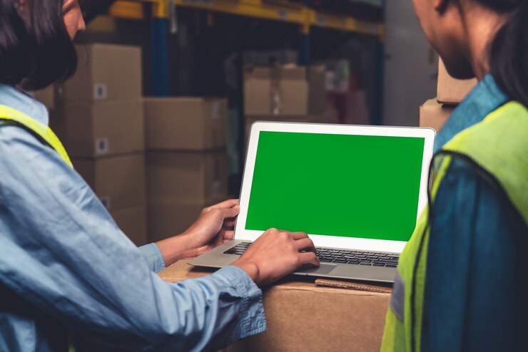 Foto computadora con pantalla verde en almacén
