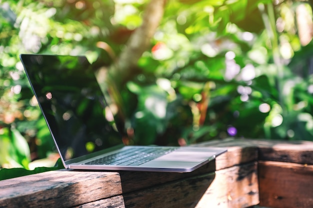 Una computadora portátil en el balcón de madera en el jardín