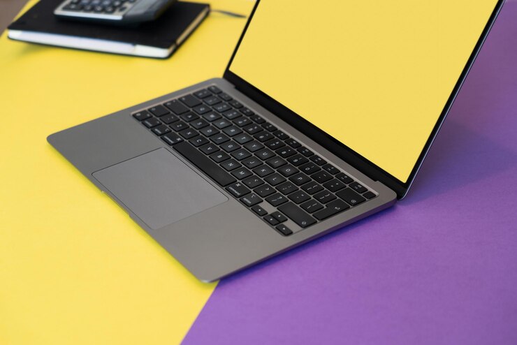 Foto una computadora portátil con una caja amarilla pantalla en blanco