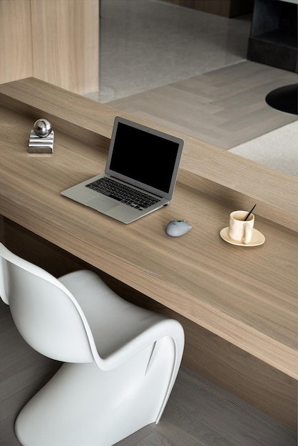 una computadora portátil está en un escritorio con un ratón y una taza de café