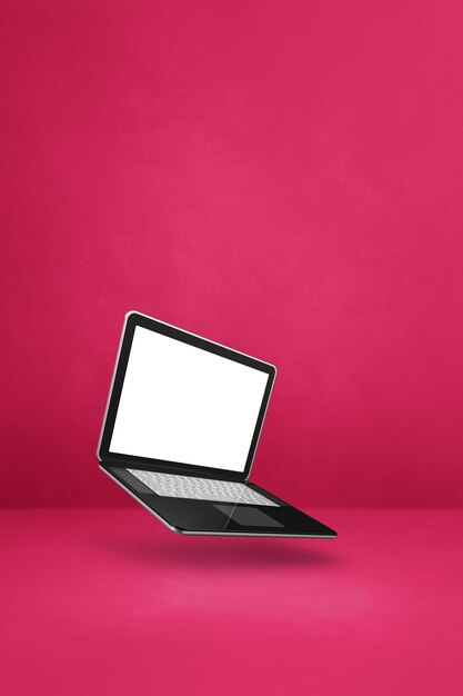 Computadora portátil flotante aislada sobre fondo vertical rosa