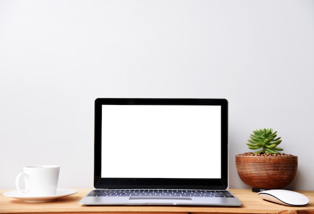 Foto computadora portátil moderna de pantalla en blanco con mouse y taza de café, escritorio de espacio de trabajo