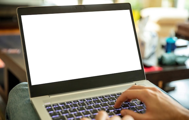 Computadora portátil con pantalla en blanco El hombre trabaja en la oficina en casa y abre el cuaderno en la pantalla vacía blanca de la pierna