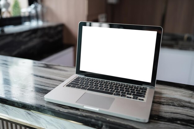 Foto computadora portátil con pantalla en blanco simulada en la mesa frente al espacio del café para el concepto de tecnología de montaje de computadora portátil de visualización de productos de texto