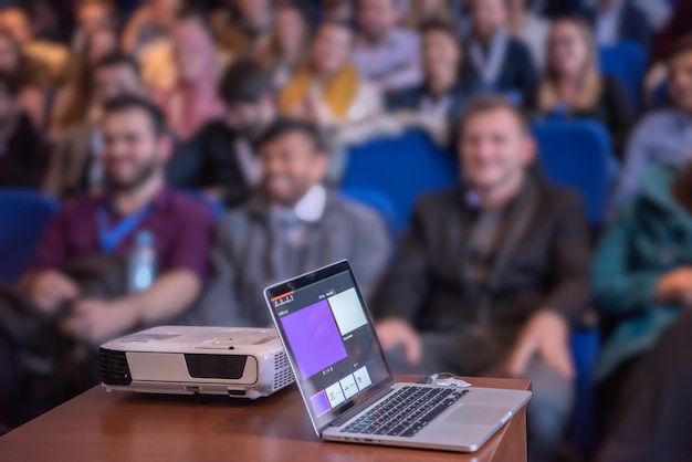 Foto computadora portátil en el podio en un seminario de negocios educación en una sala de conferencias moderna