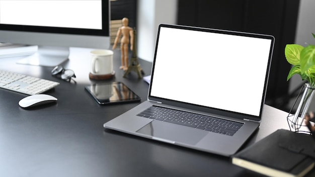 Computadora portátil portátil teléfono inteligente y taza de café en el escritorio de oficina blanco Lugar de trabajo moderno