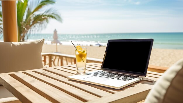 Una computadora portátil con un ratón en un escritorio de madera junto a una bebida refrescante con vistas a una playa soleada que sugiere trabajo remoto o relajación de vacaciones