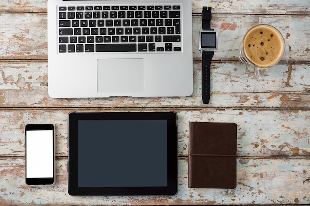 Computadora portátil, reloj inteligente, teléfono inteligente y tableta digital con taza de café