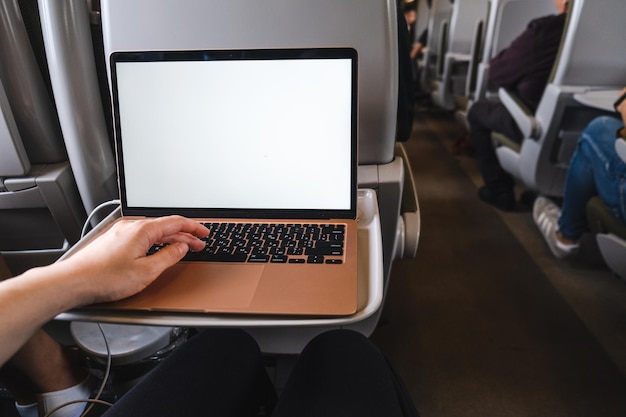 Una computadora portátil se sienta encima de una mesa en un vagón de tren que proporciona un espacio de oficina móvil