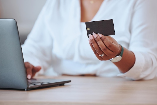 Computadora portátil con tarjeta de crédito y finanzas con una mujer de negocios que paga sus facturas e hipotecas en línea Mujer negra que ordena manos y banca mientras ahorra dinero en su cuenta bancaria para un presupuesto o préstamo