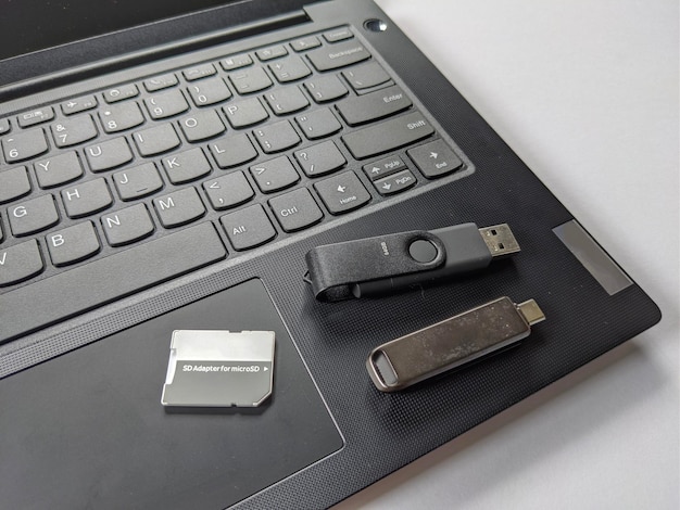 Una computadora portátil con una tarjeta SD y un pendrive en un fondo aislado