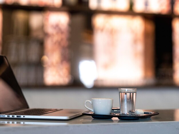 Una computadora portátil y una taza de café turco.