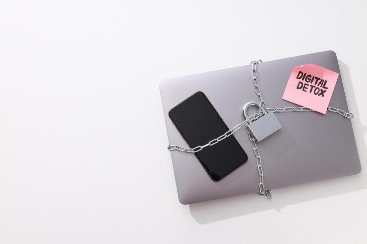 La computadora portátil y el teléfono inteligente están envueltos en una cadena con candado.