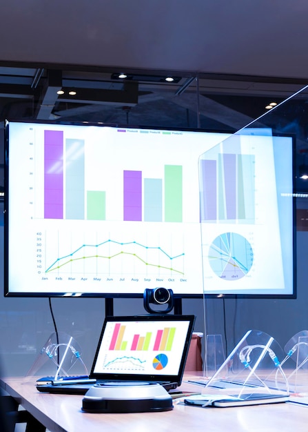 Computadora portátil y televisión con presentación de diapositivas en la sala de reuniones