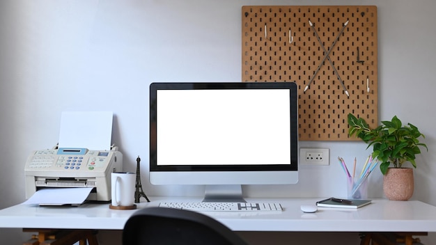 Computadora de vista frontal con planta de interior de pantalla vacía y papelería en mesa blanca Escritorio de oficina en casa