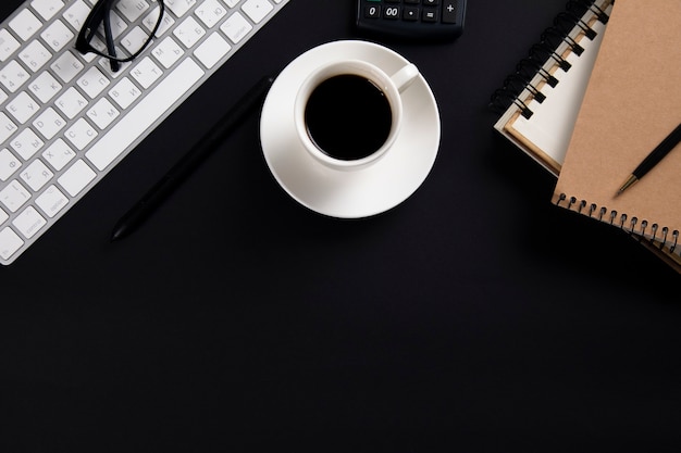 Computer mit Notizblock und Kaffee mit Taschenrechner auf Bürotisch