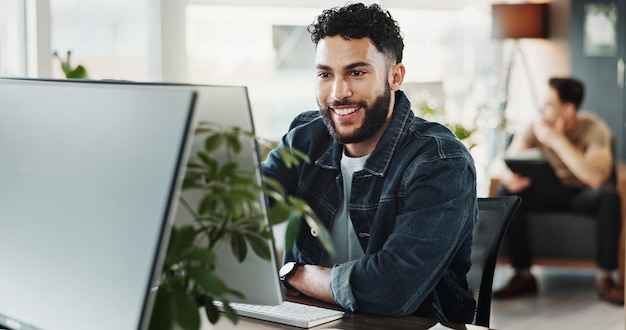 Computer smile and web development with man in creative workplace for coding or design Cybersecurity programming and system infrastructure with happy employee person in office as website developer