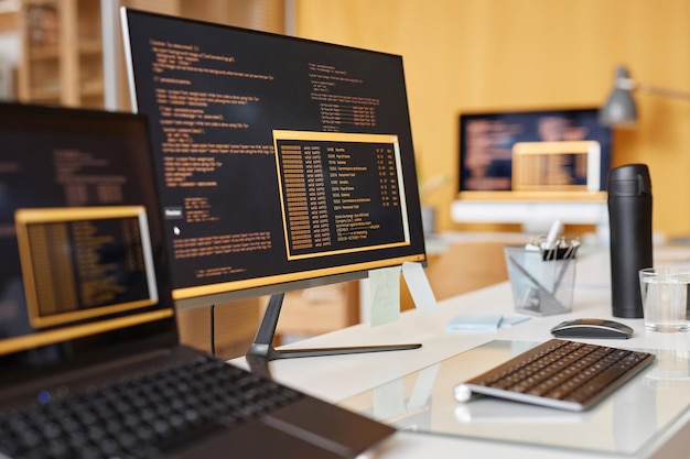 Computerbildschirm mit Codezeilen auf dem Schreibtisch in seinem Entwicklungsbüro schließen
