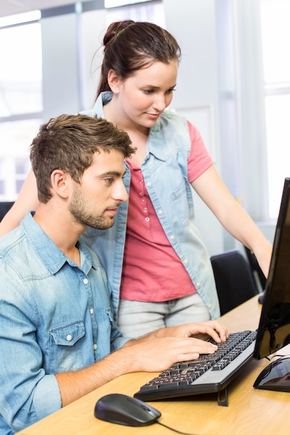 Computerlehrer, der hübscher Studentin hilft