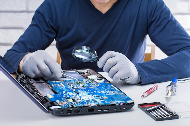 Computermechaniker, der den defekten Laptop im Labor repariert Computer-Reparaturservice.