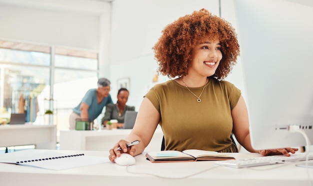 Computermode und -design mit einer Geschäftsfrau bei der Arbeit in ihrem Büro für modernen oder künstlerischen Stil Lächeln Sie Workshop und Technologie mit einer glücklichen jungen Designerin, die in einem Kreativstudio arbeitet