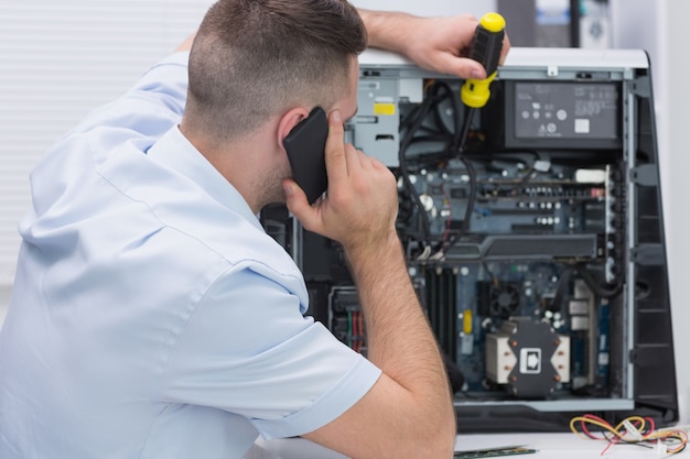 Computertechniker, der an cpu während beim anruf arbeitet