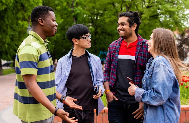 Foto comunicação ao ar livre entre estudantes universitários multirraciais alegres