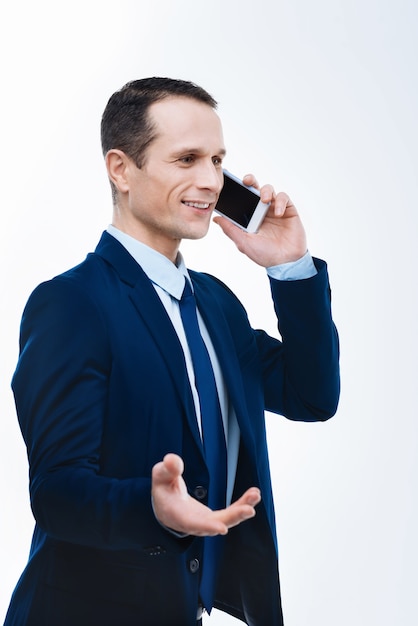 Comunicação Empresarial. Homem de negócios inteligente e positivo, segurando um telefone e conversando enquanto discute problemas de negócios