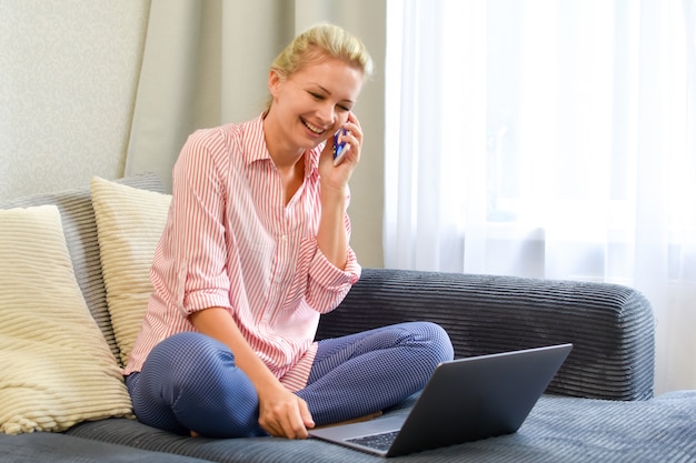 comunicação empresarial online a partir de casa. trabalho remoto com laptop, mulher com telefone