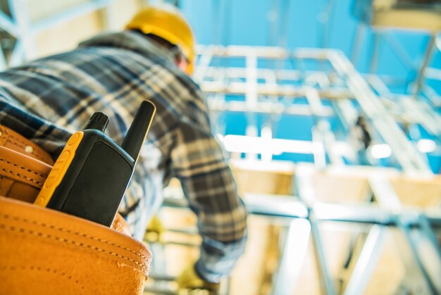 Foto comunicação no local de construção walkietalkie dispositivo de rádio em ferramentas de empreiteiros cinturão closeup foto